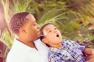 hijo de raza mixta y padre afroamericano jugando juntos al aire libre. foto