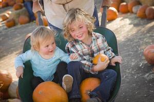 familia joven disfruta de un día en el huerto de calabazas foto