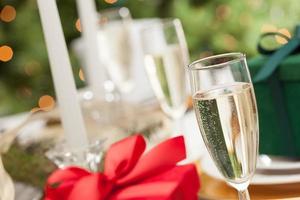 Champagne Glass and Christmas Gift with Place Setting Abstract at Table photo