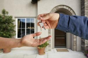 Handing Over the House Keys in Front of New Home photo