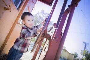 Cute Young Mixed Race Boy Having Fun on Railroad Car photo