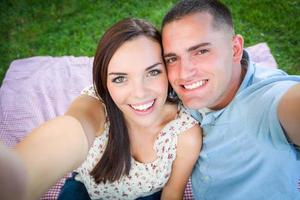 Happy Young Caucasian Couple Shooting Selfie in the Park. photo