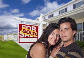 Hispanic Couple, New Home and Sold Real Estate Sign photo