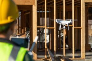 mujer piloto vuela drone quadcopter inspeccionando el sitio de construcción foto