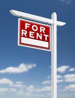 Left Facing For Rent Real Estate Sign on a Blue Sky with Clouds. photo