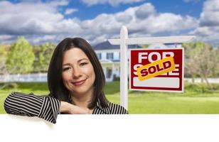 Hispanic Woman in Front of Sold For Sale Sign, House photo