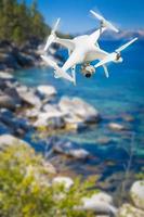 Unmanned Aircraft System  Quadcopter Drone In The Air Over Lake Tahoe. photo