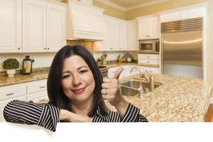 mujer hispana con los pulgares hacia arriba en el interior de la cocina personalizada foto