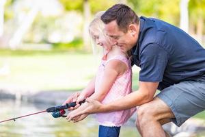 Young Caucasian Father and Daughter Having Fun Fishing At The Lake photo