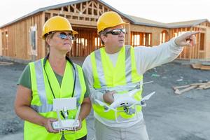 trabajadores con drone quadcopter inspeccionando fotografías en el controlador en el sitio de construcción foto