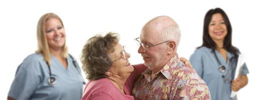 Senior Couple with Medical Doctors or Nurses Behind photo