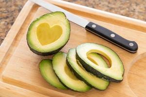 Fresh Cut Avocado With Heart Shaped Pit Area On Wooden Cutting Board photo