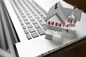 Miniature House on Laptop Computer photo
