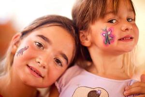 lindas chicas mostrando su cara pintada en una fiesta foto