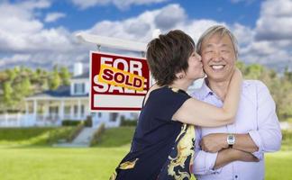 Affectionate Senior Chinese Couple In Front of House and Sign photo