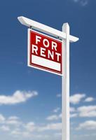 Left Facing For Rent Real Estate Sign on a Blue Sky with Clouds. photo