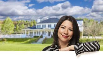 Hispanic Woman Leaning on White in Front of House photo