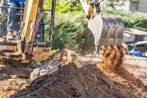 Working Excavator Tractor Digging A Trench At Construction Site photo