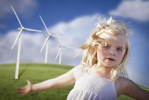 hermosa joven jugando en el campo de la turbina de viento foto