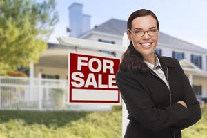 Young Woman in Front of House and Sale Sign photo