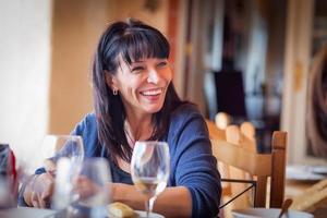 Pretty Italian Woman Enjoys A Meal And Drinks with Friends at Outdoor Restaurant photo