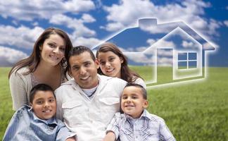 Hispanic Family Sitting in Grass Field with Ghosted House Behind photo