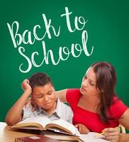 Back To School Written On Chalk Board Behind Hispanic Young Boy and Famale Adult Studying photo