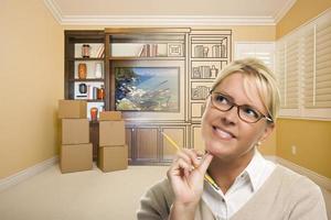 Female Holding Pencil In Room With Drawing of Entertainment Unit photo