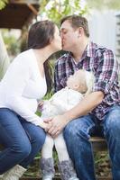 feliz pareja embarazada se besa mientras la niña mira foto