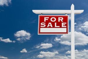Left Facing For Sale Real Estate Sign Over Blue Sky and Clouds With Room For Your Text. photo