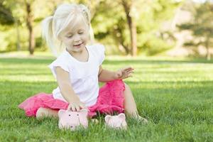 niña divirtiéndose con sus alcancías afuera foto