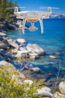 Back of Unmanned Aircraft System UAV Quadcopter Drone Flying Above Lake Tahoe photo