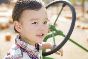 Mixed Race Young Boy Playing on Tractor photo