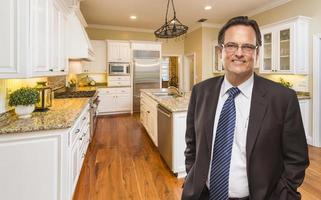 hombre vestido con corbata en una hermosa cocina residencial personalizada foto