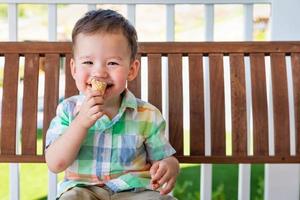 Young Mixed Race Chinese and Caucasian Boy Enjoying His Ice Cream Cone photo