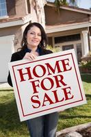 Woman Holding Home For Sale Real Estate Sign In Front of House photo