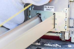 Worker Measuring Rain Gutter Processing Through Seamless Shaping Machine photo