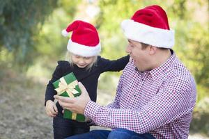 padre dando joven hija regalo de navidad foto