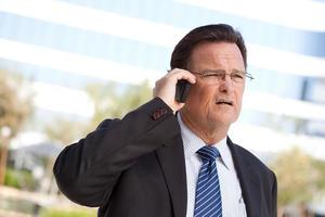 Concerned Businessman Talks on His Cell Phone photo