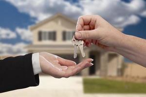 Handing Over the House Keys in Front of New Home photo