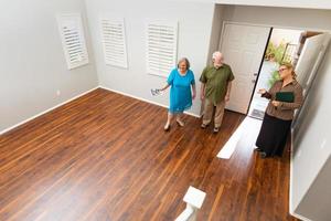 Female Real Estate Agent Showing Senior Adult Couple A New Home photo