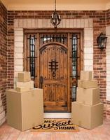 Several Packages Sitting on Home Sweet Home Welcome Mat At Front Door of House. photo