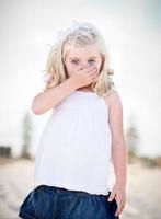 Adorable Blue Eyed Girl Covering Her Mouth photo