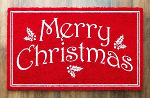 Merry Christmas Red Welcome Mat On Wood Floor Background photo