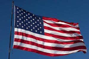 American Flag Waving In Wind Against a Deep Blue Sky photo