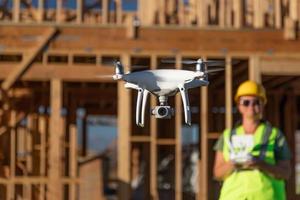 mujer piloto vuela drone quadcopter inspeccionando el sitio de construcción foto