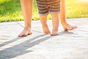 pies de madre y bebé dando pasos al aire libre foto