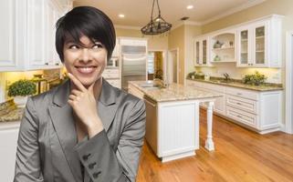 Mixed Race Woman Looking Back Over Shoulder Inside Custom Kitchen photo