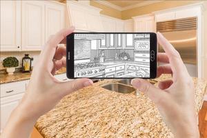 Hands Holding Smart Phone Displaying Drawing of Kitchen Photo Behind