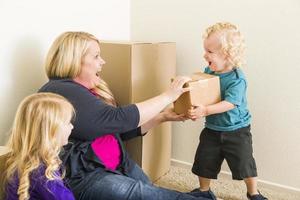 Young Family In Empty Room Playing With Moving Boxes photo